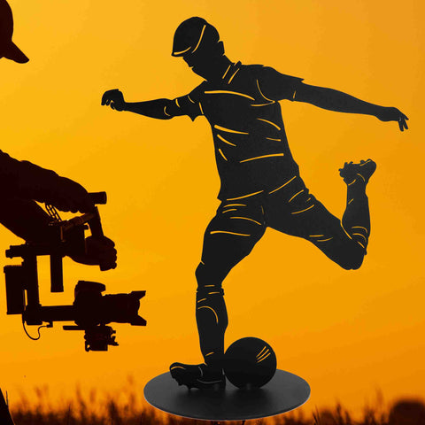 Dekofigur eines Fußballspielers in schwarzem Matt-Finish, lebhaft in Aktion mit einem Fußball, ideal für sportliche Akzente im Wohnbereich oder Outdoor-Dekoration.