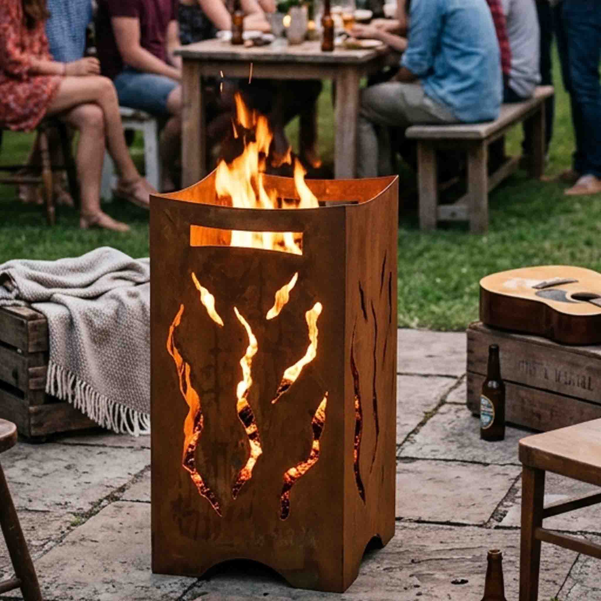 Feuertonne mit Flammen-Motiv im Lasercut bei der Gartenparty – Feuerschein tanzt durch die Ausschnitte, 3 mm Stahl, fertig gerostet.