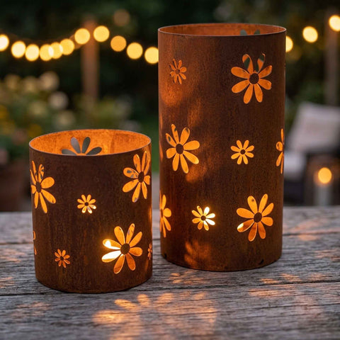 Zwei Edelrost Windlichter mit Blumenmuster und brennenden Kerzen als stimmungsvolle Tischdeko